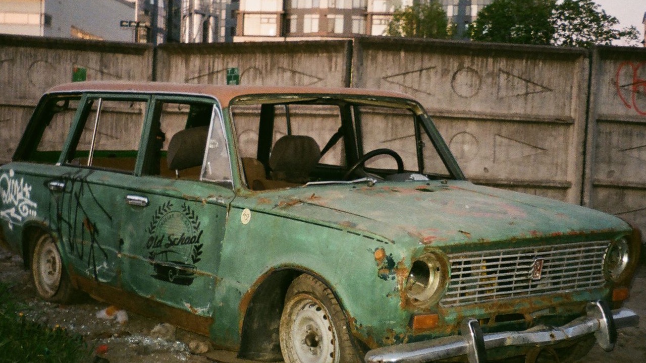 Abandoned vintage car in Oakland with graffiti and rust